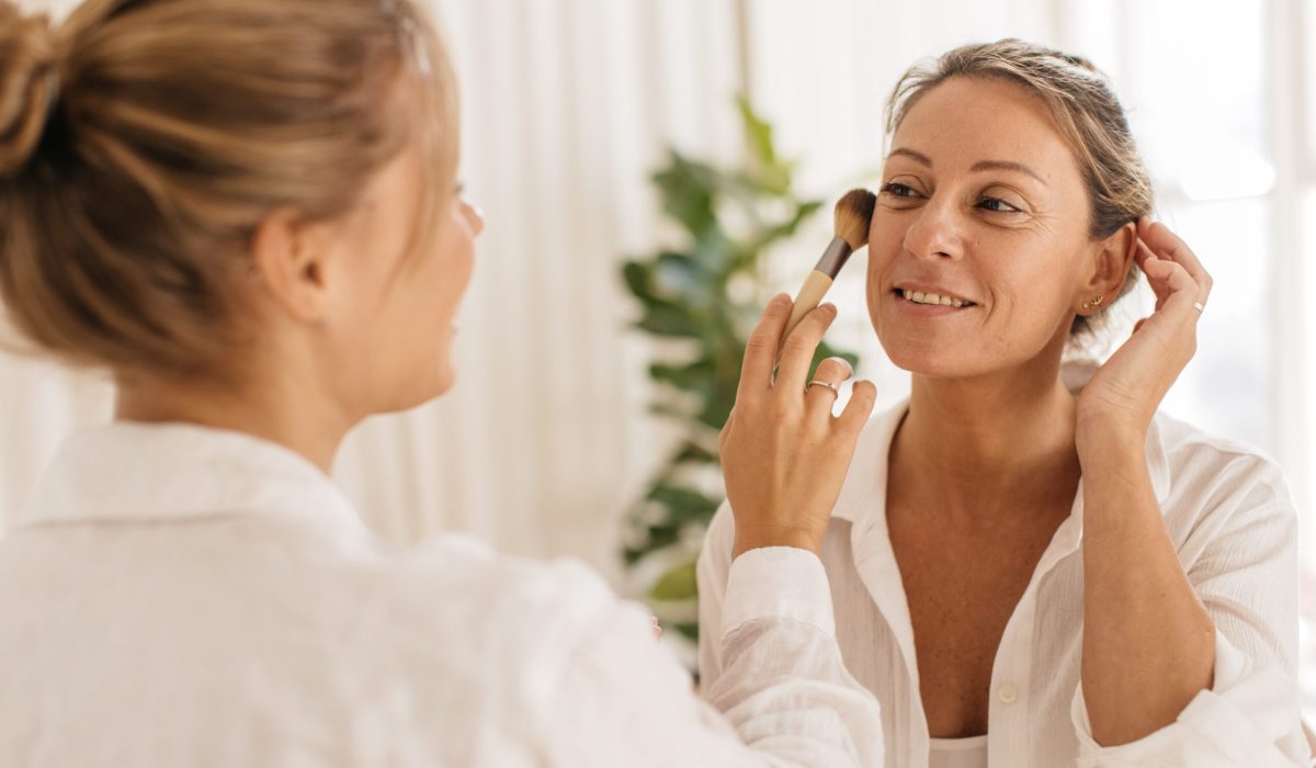 fair-skinned-lady-applying-makeup-with-brush-adult-blonde-woman-white-shirt-indoors-cosmetic-products-concept